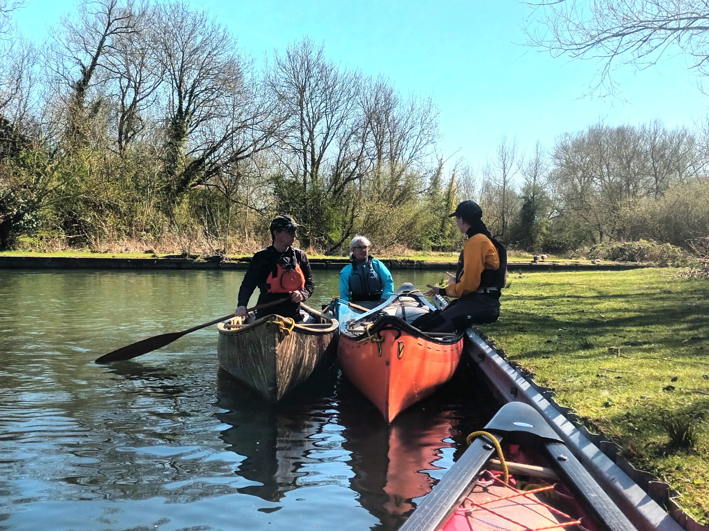 A sheltered water canoe performance coach chatting to her students